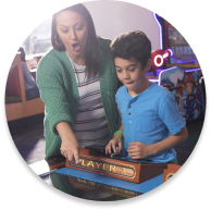 niño y madre juegan juntos al arcade