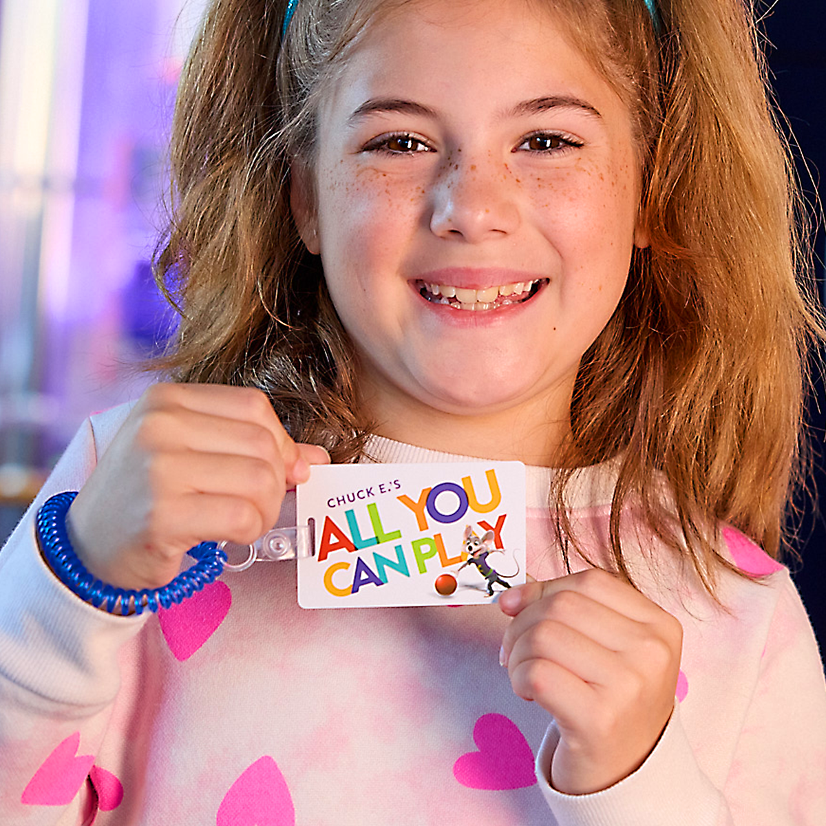 una niña sosteniendo una tarjeta Juega todo lo que puedas