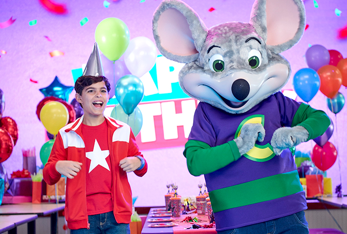 chuck e y el niño del cumpleaños bailan una coreografía divertida con globos